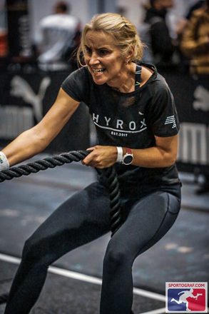 Juliet pulling a heavy rope at a HYROX fitness race