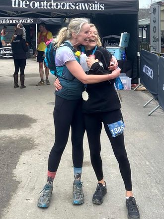 Juliet hugging a friend at a trail race finish